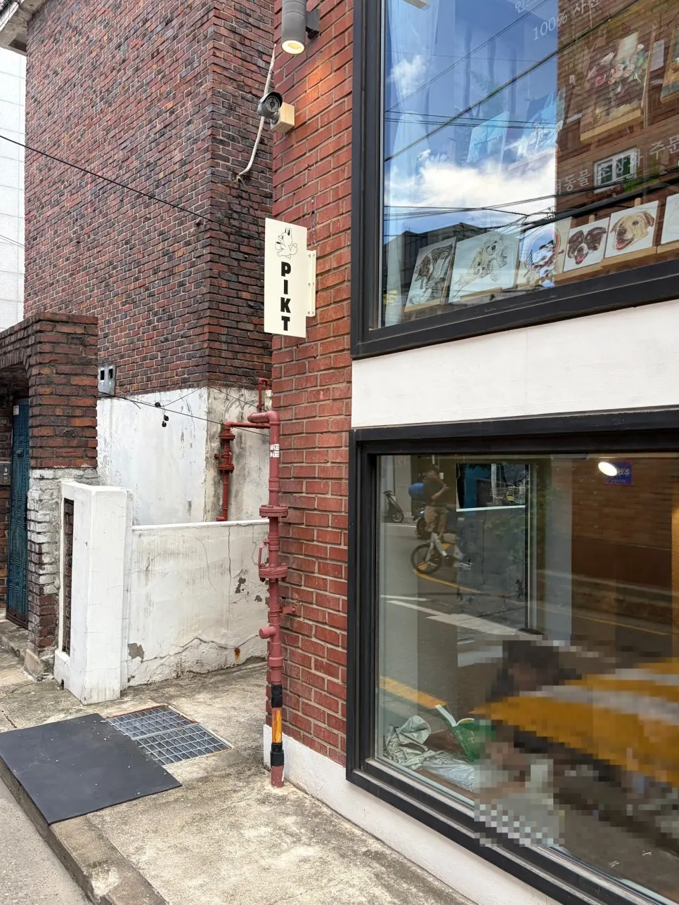 Entrance of the glass-walled café in a brick house