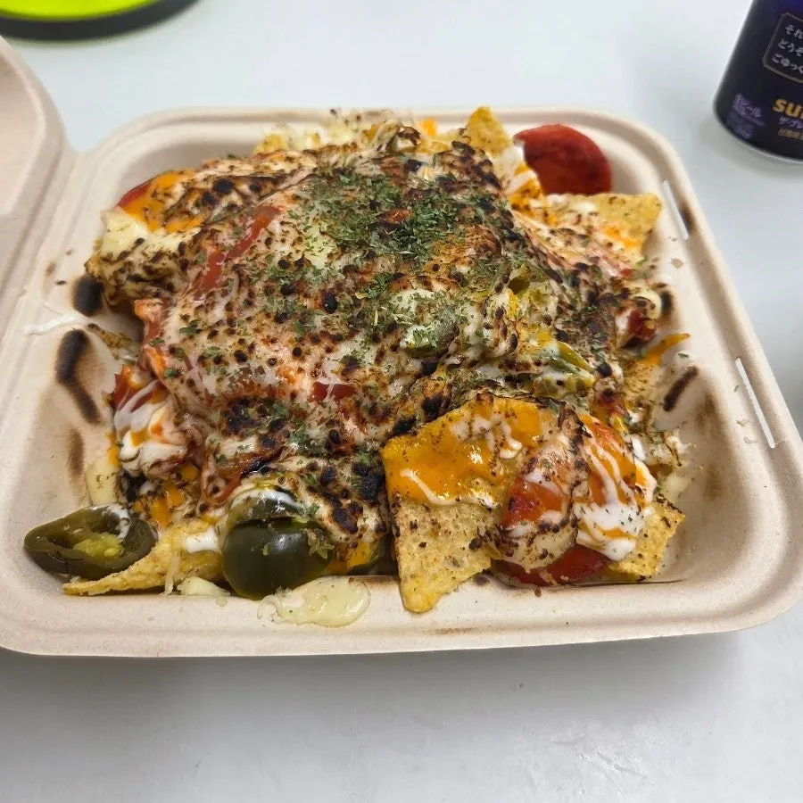 Pepperoni pizza nachos set out alongside beer