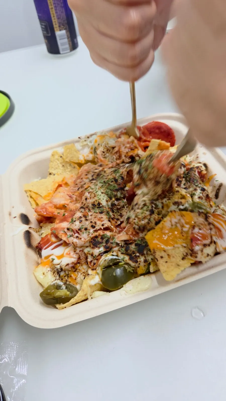 Close-up of nachos topped with jalapeños and pepperoni