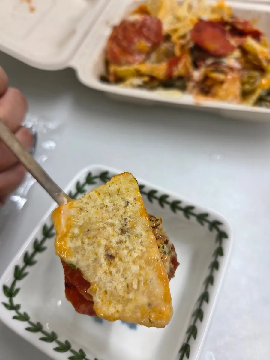 Breaking off pieces of cheese from the nachos with a fork