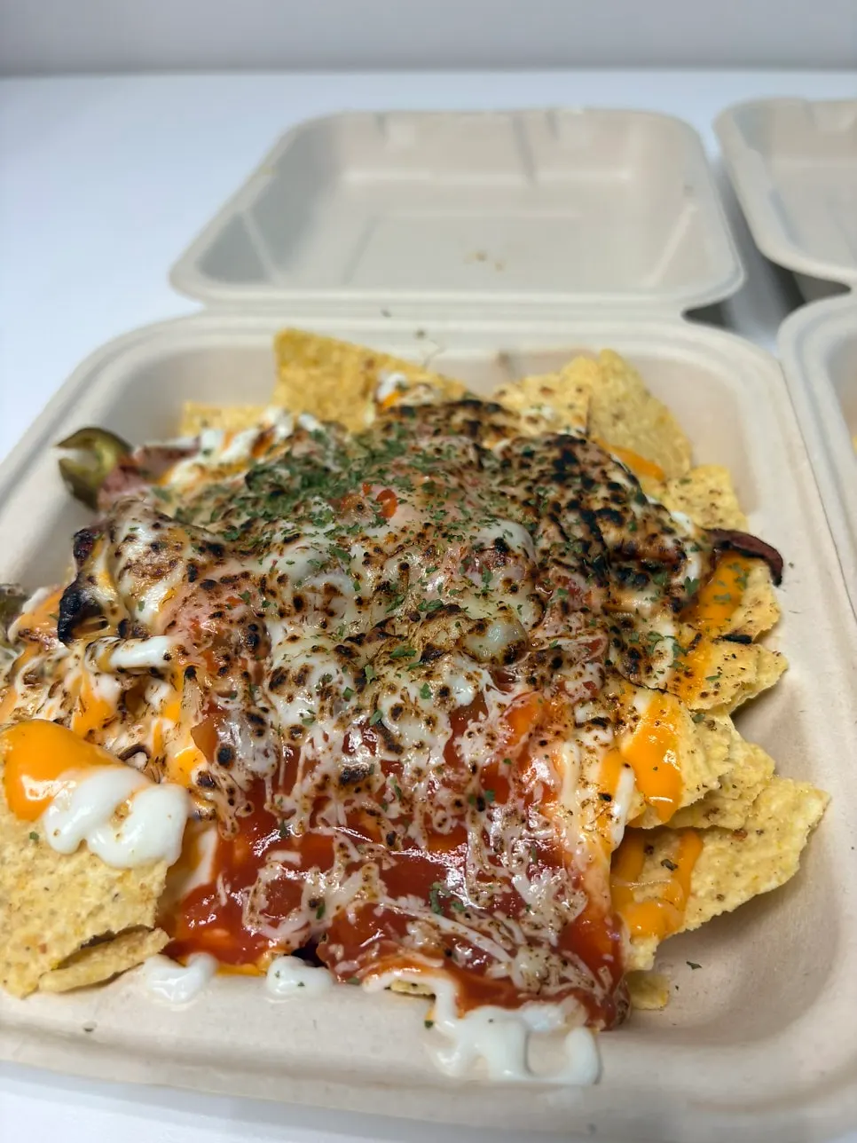 Two nacho takeout containers set on the home dining table