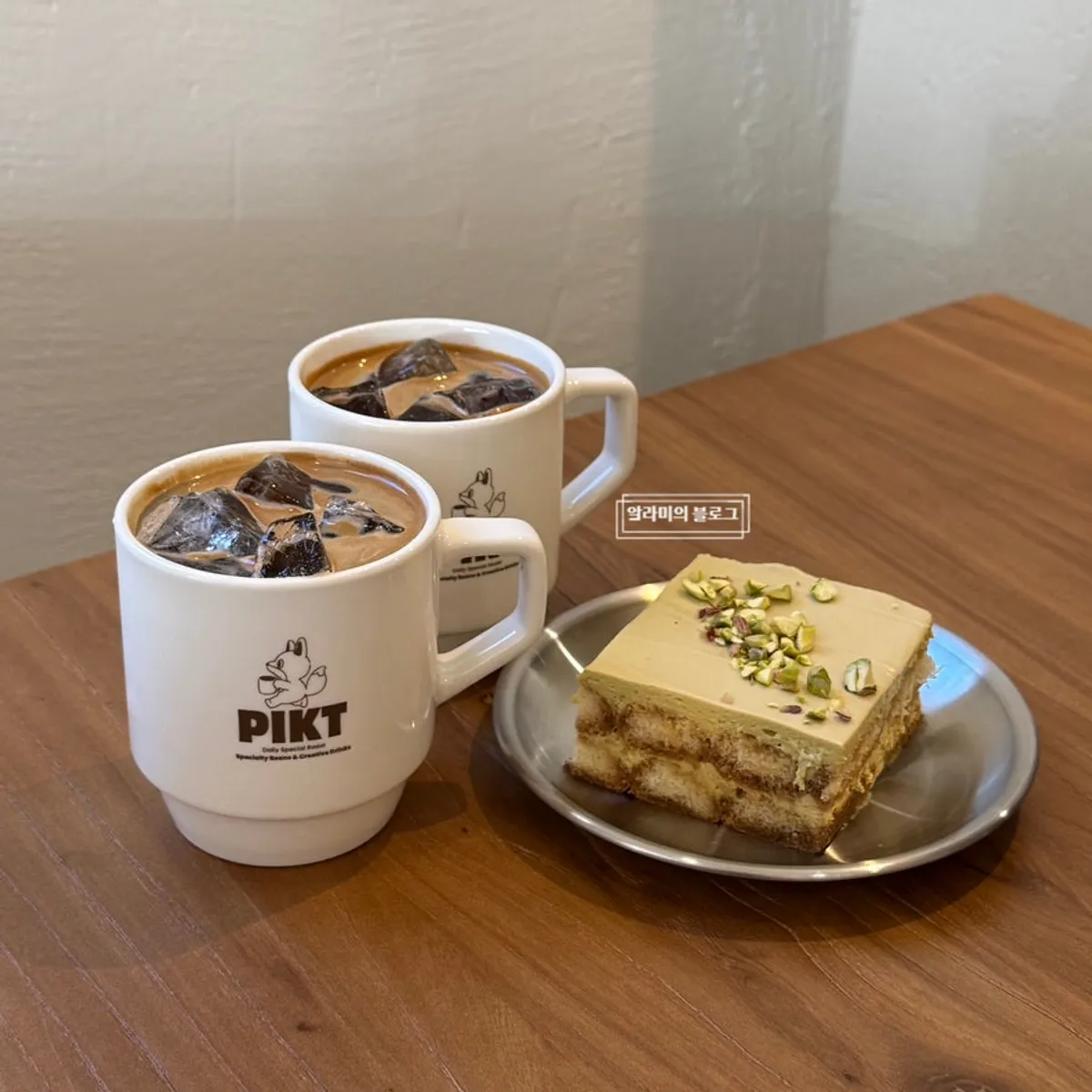 Two iced americanos packed with ice and a pistachio tiramisu
