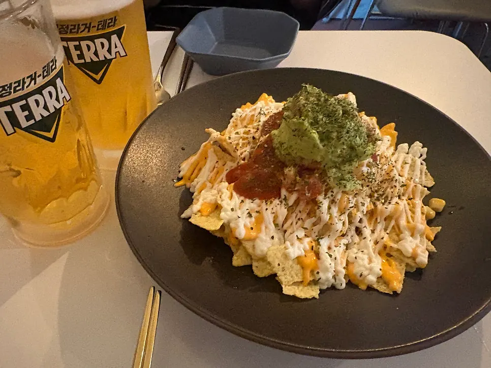 Draft beer served alongside Macho Nacho's nachos