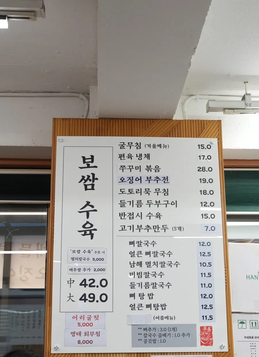 Menu board showing bossam and anchovy kalguksu