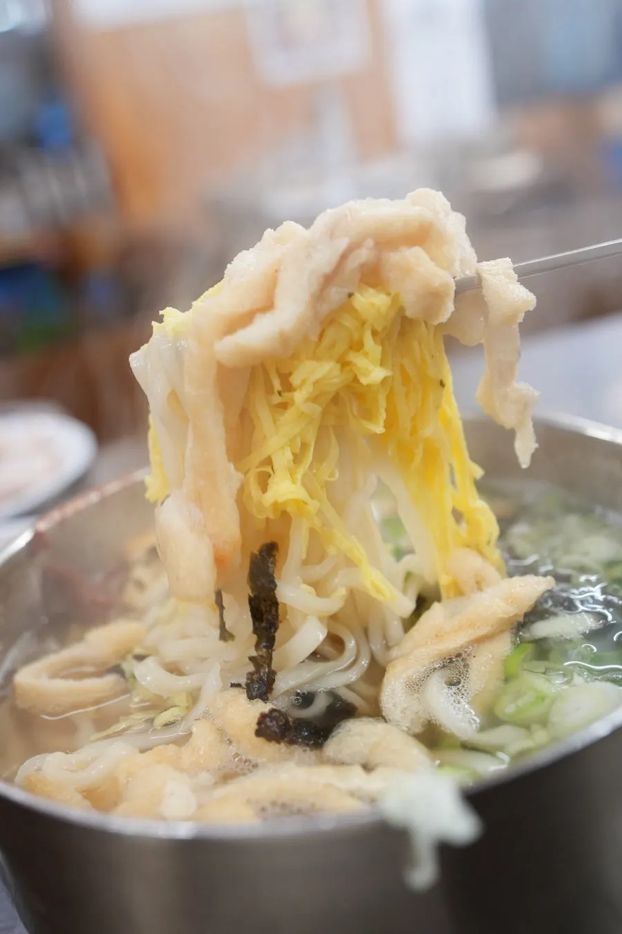 Anchovy kalguksu topped with fried tofu and egg ribbons