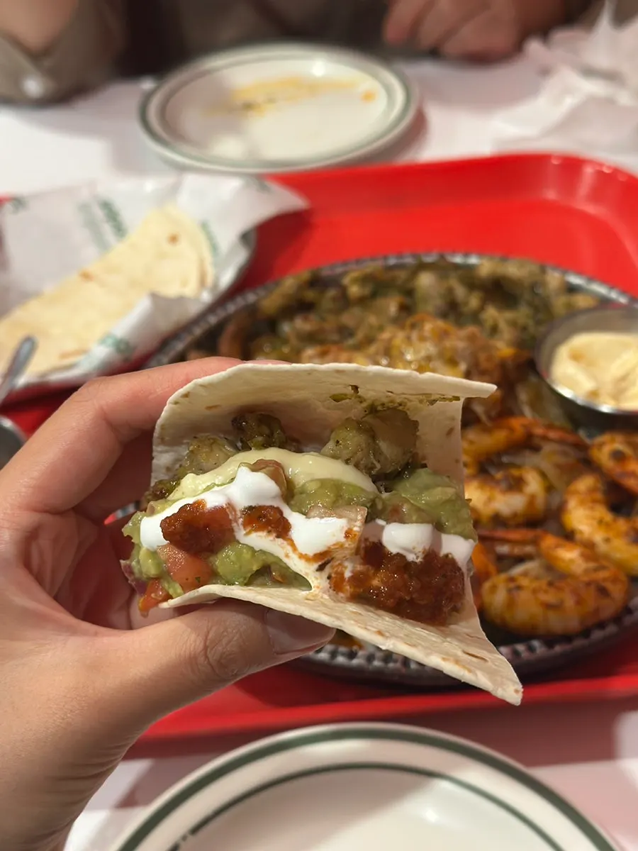 A bite of fajita topped with extra guacamole