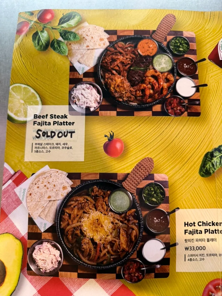 Menu board listing fajita and chimichanga at Taco Dot