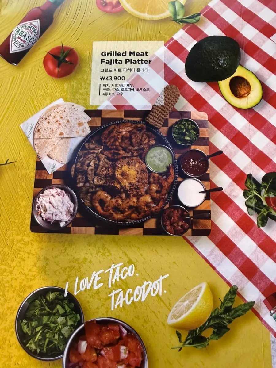 Menu board showing enchilada options at Taco Dot