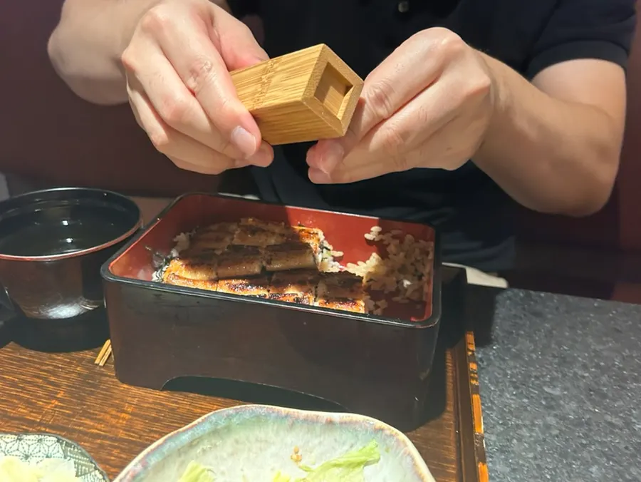 A piece of eel picked up with chopsticks