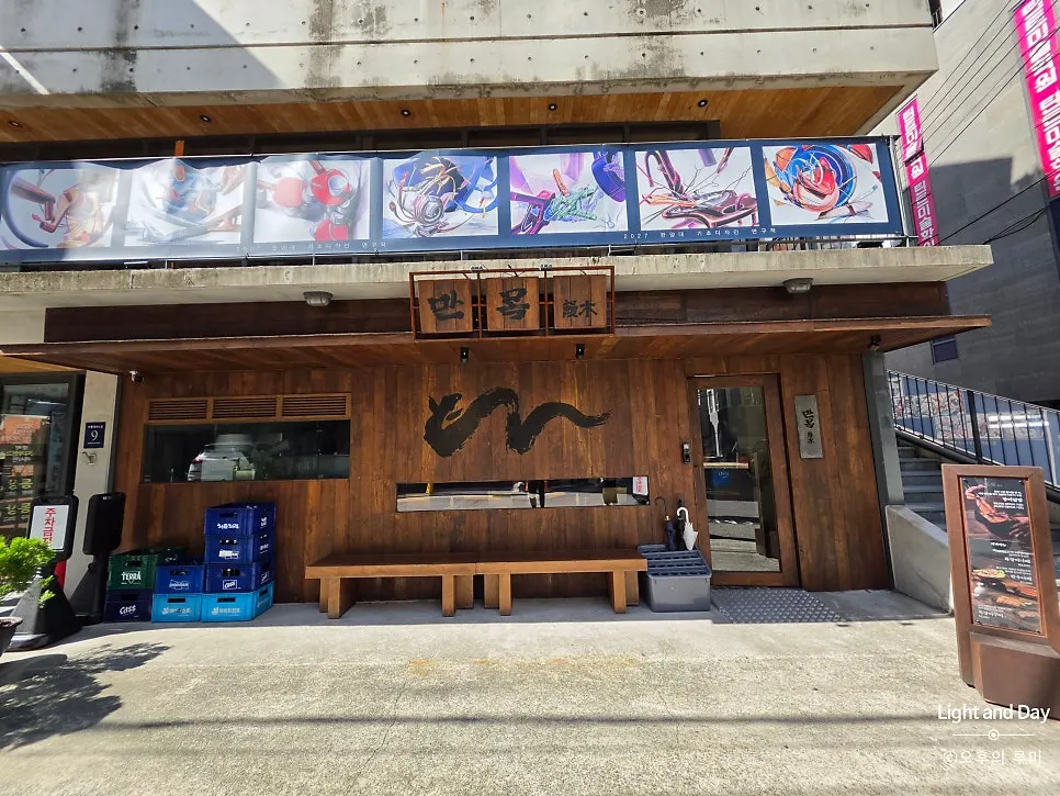 Manmok's wooden sign with an eel illustration
