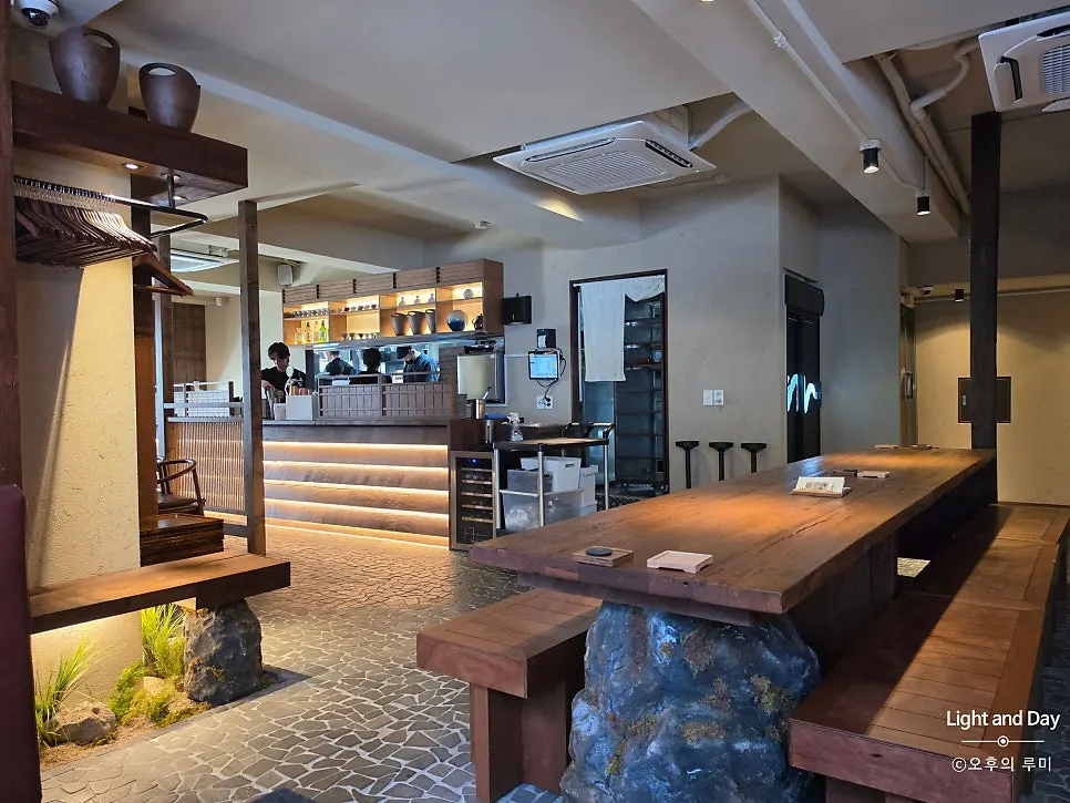 Manmok's open bar counter lined with ceramic sake bottles