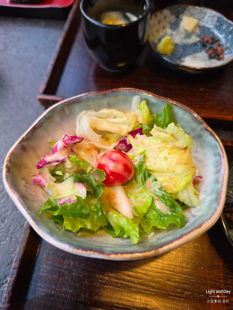 A bite of eel rice bowl with white kimchi and radish salad