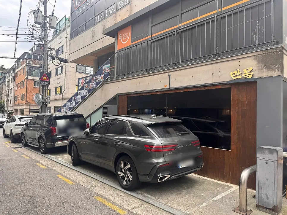 Alley entrance to Manmok with parking signage visible