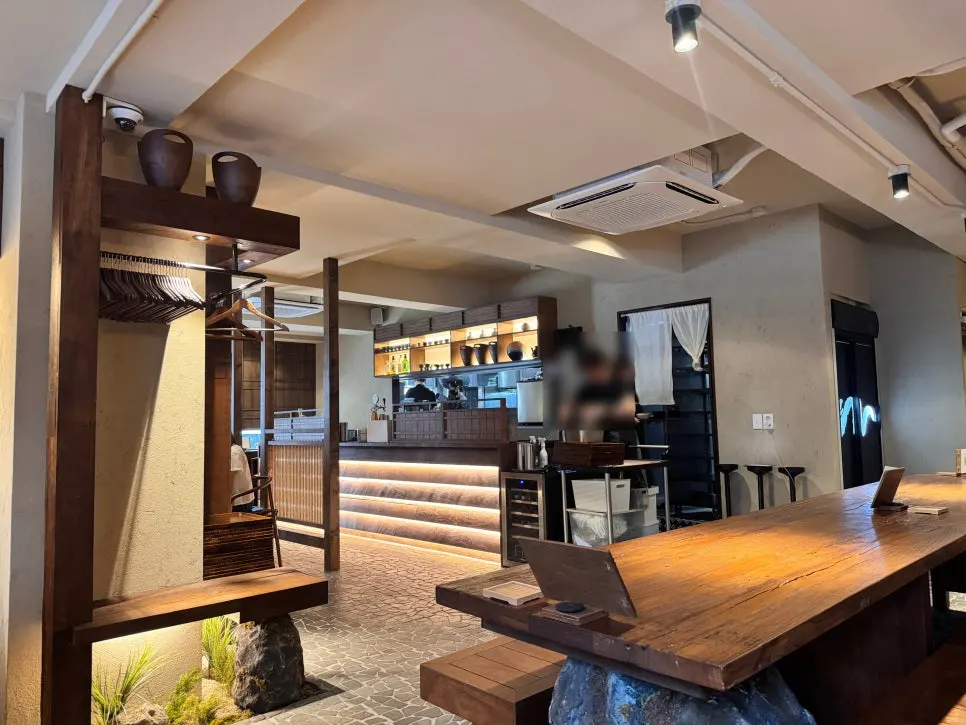 Manmok's interior in dark brown wood tones with an ink-wash landscape painting