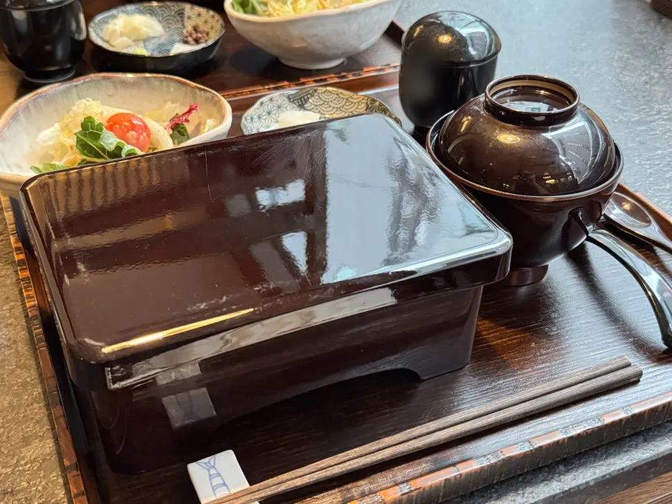Wooden tray with lacquered box, steamed egg custard, clear soup, and salad