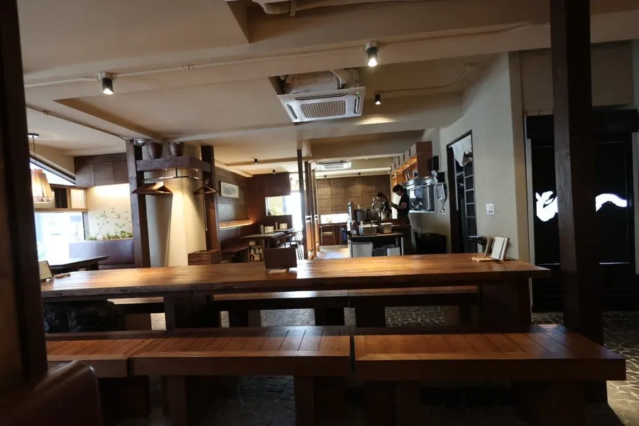 Interior of Manmok with wood-toned furniture and soft lighting