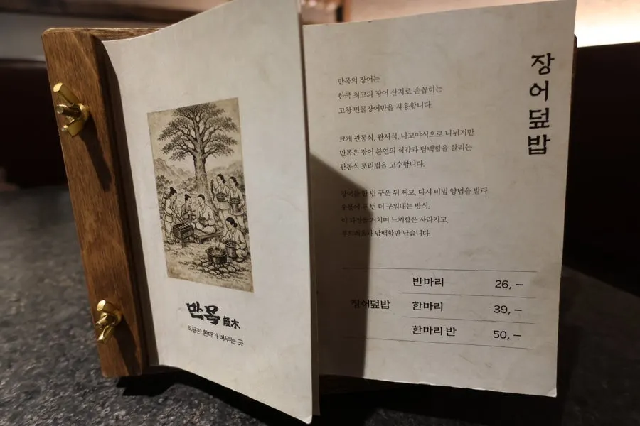 Manmok's menu board with eel rice bowl prices