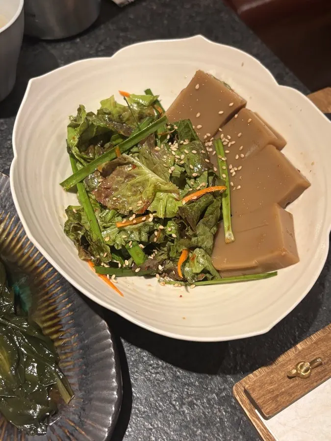Basic table setting with wild garlic leaves, white kimchi, seasoned radish, and four sauces