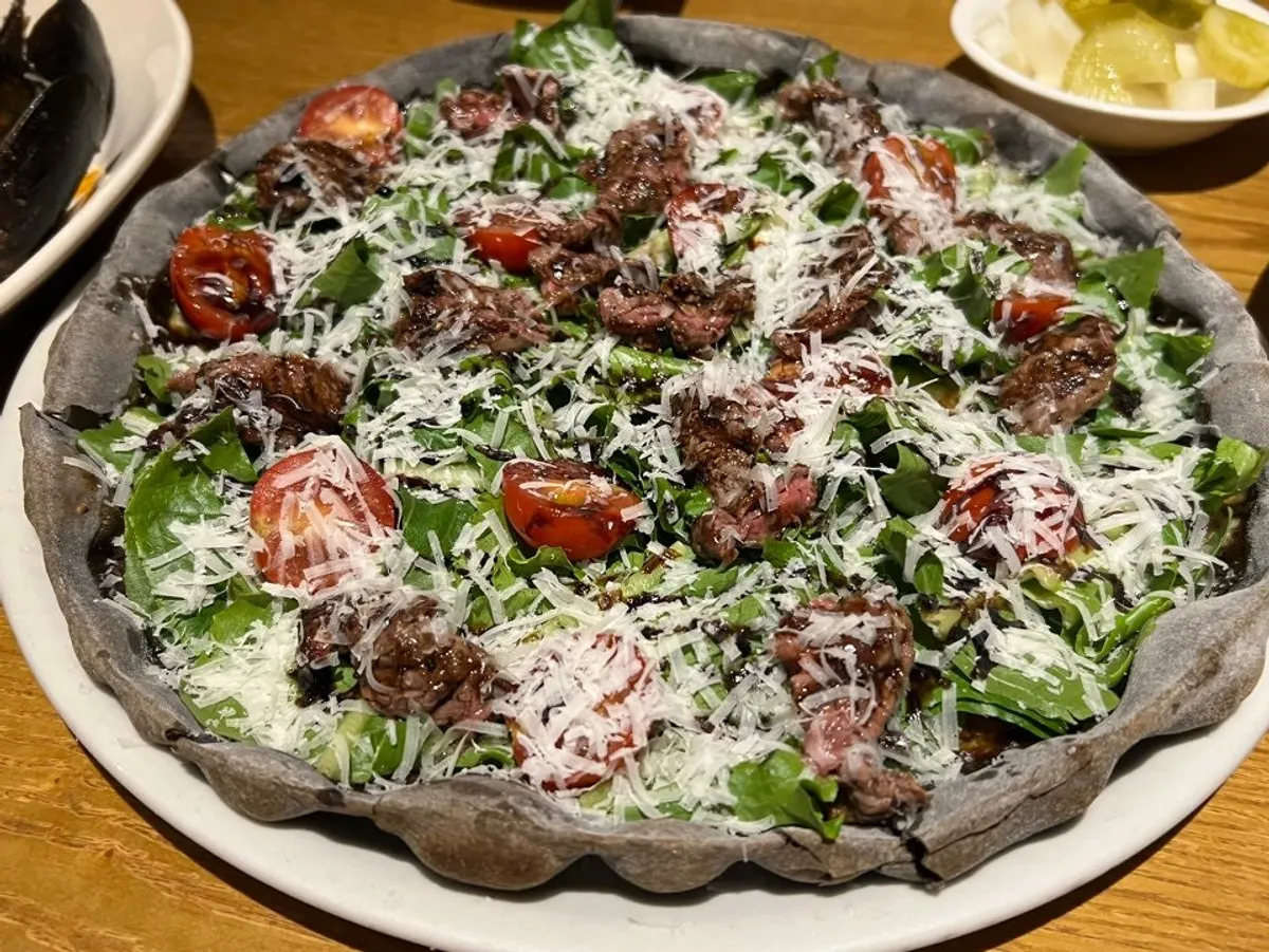 Steak pizza with tenderloin steak on squid-ink dough