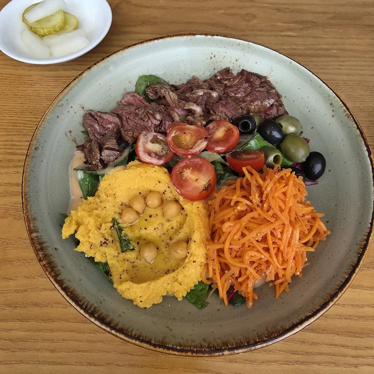A plate of carrot hummus steak