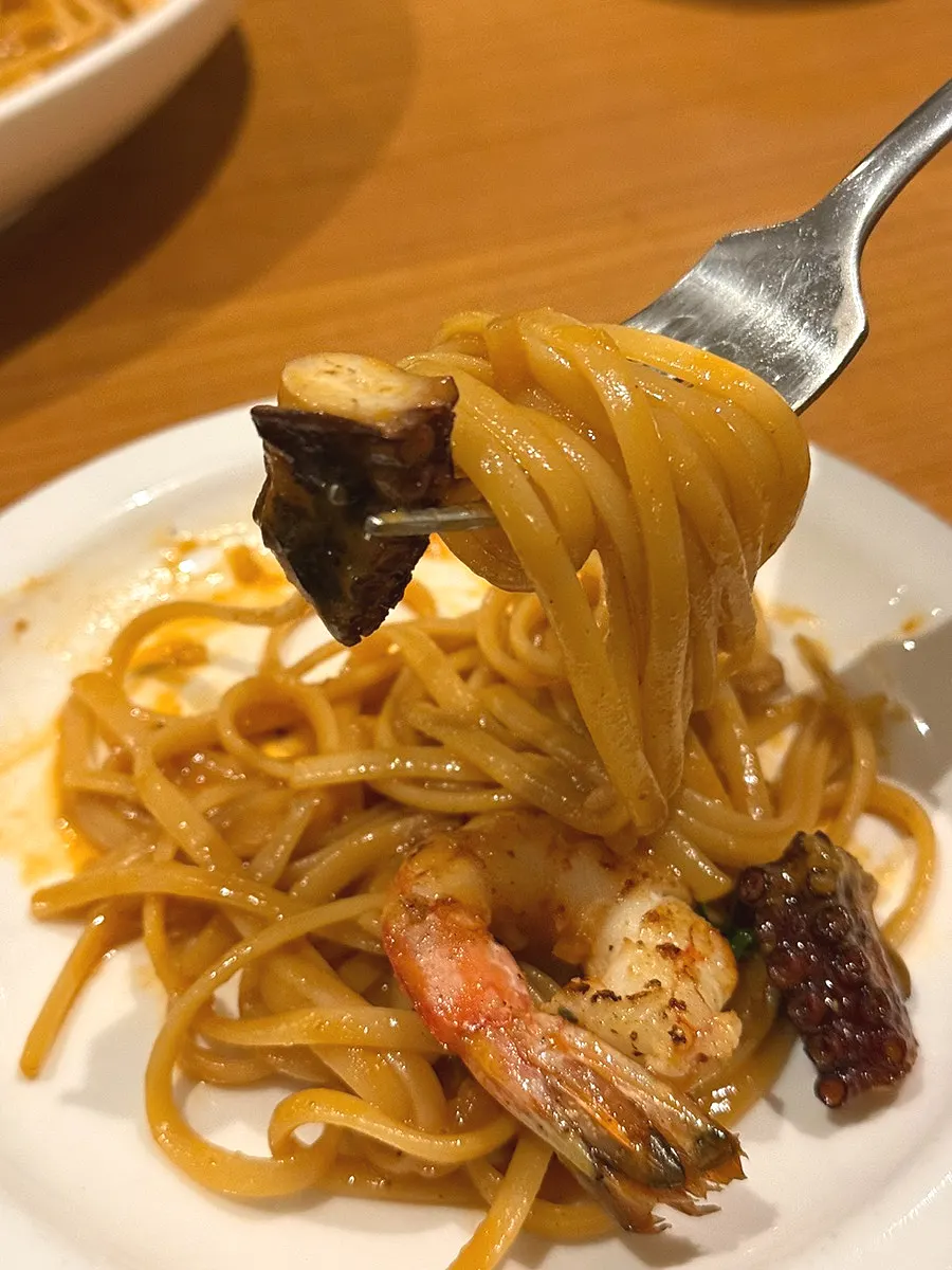 Red shrimp bisque linguine topped with octopus and whole shrimp