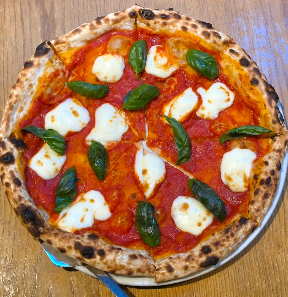 Margherita pizza topped with tomato sauce, mozzarella, and basil