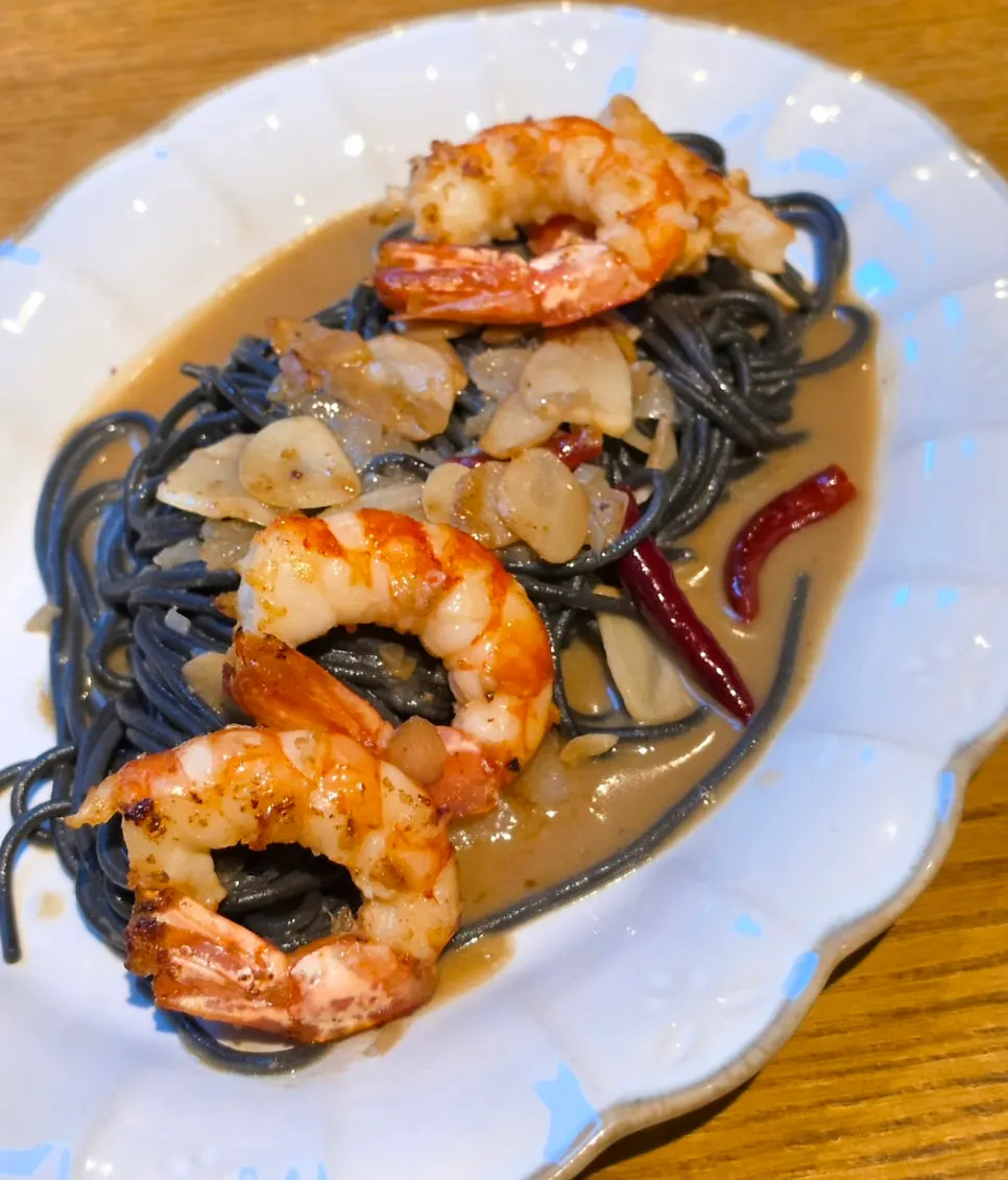 Large red shrimp on top of the ink noodles