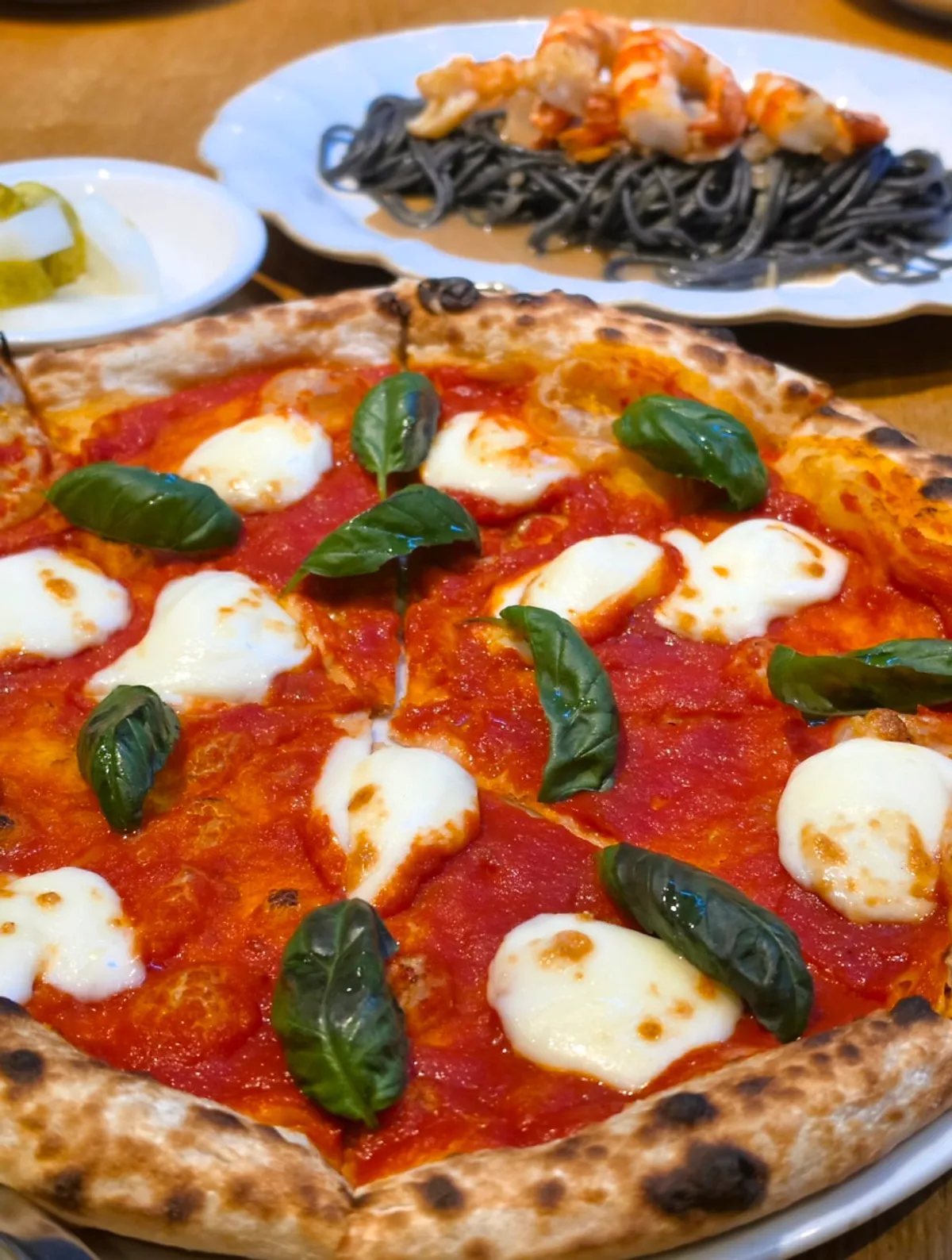 Table with margherita pizza and red shrimp aglio e olio