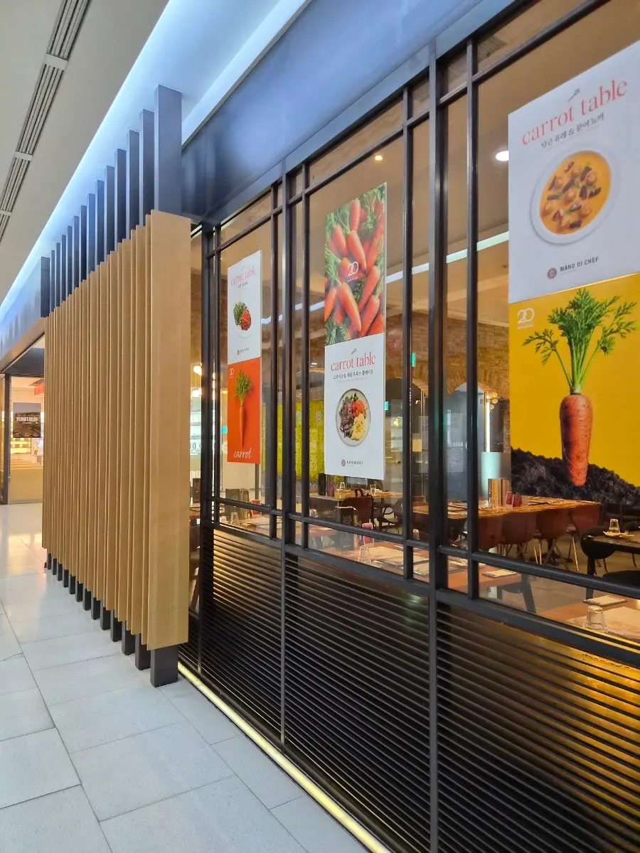 ウッドルーバーの隙間にあるマノディシェフ蚕室店の看板