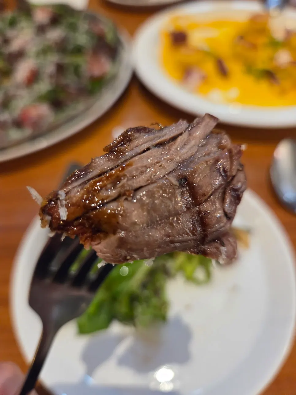 A slice of steak pizza lifted up