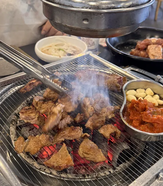 Handmade marinated galbi grilling over charcoal