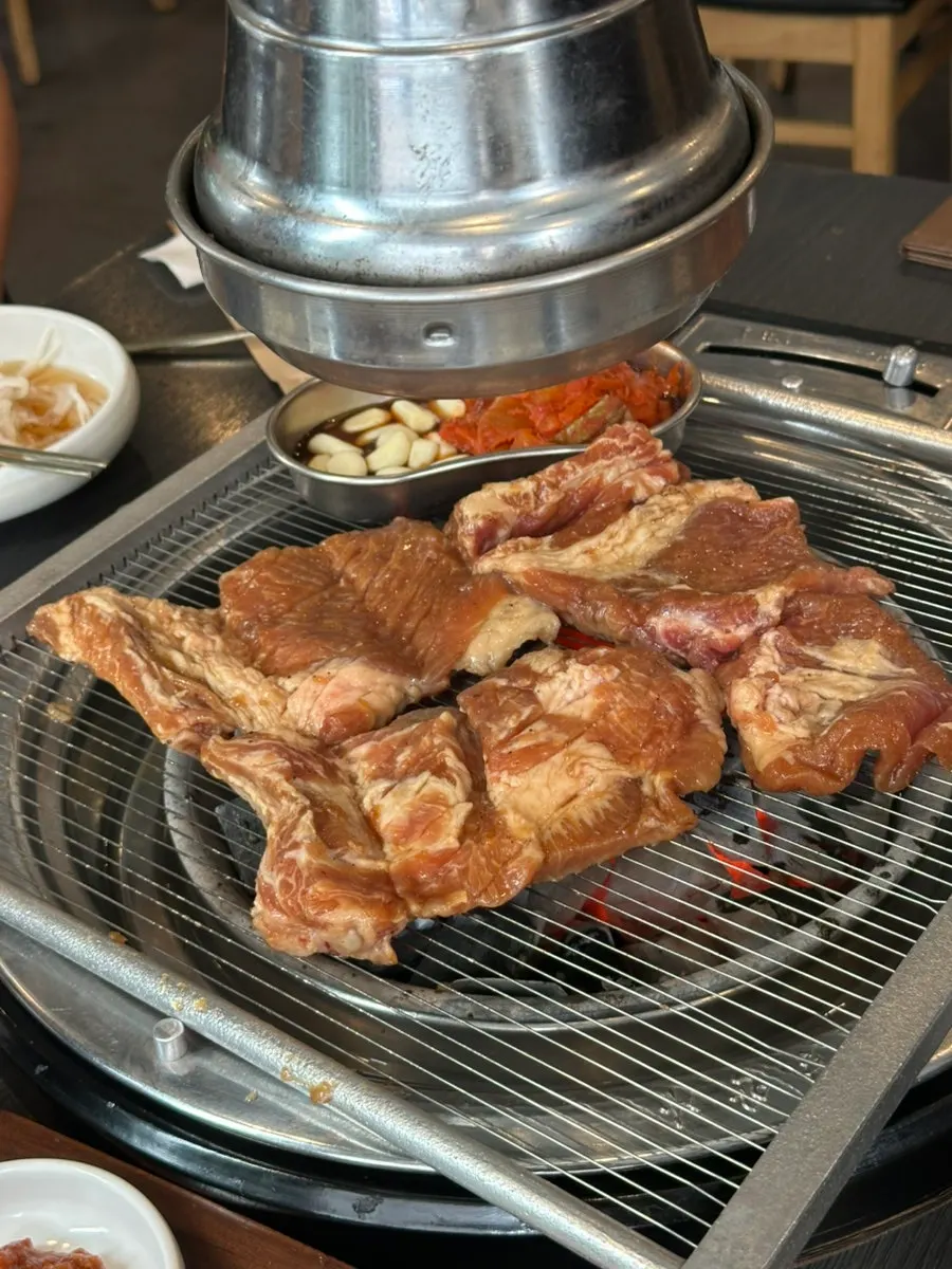 Four servings of marinated pork galbi on the charcoal grill