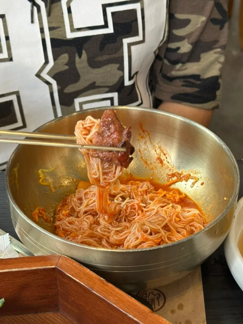 Marinated galbi placed on top of bibim-naengmyeon