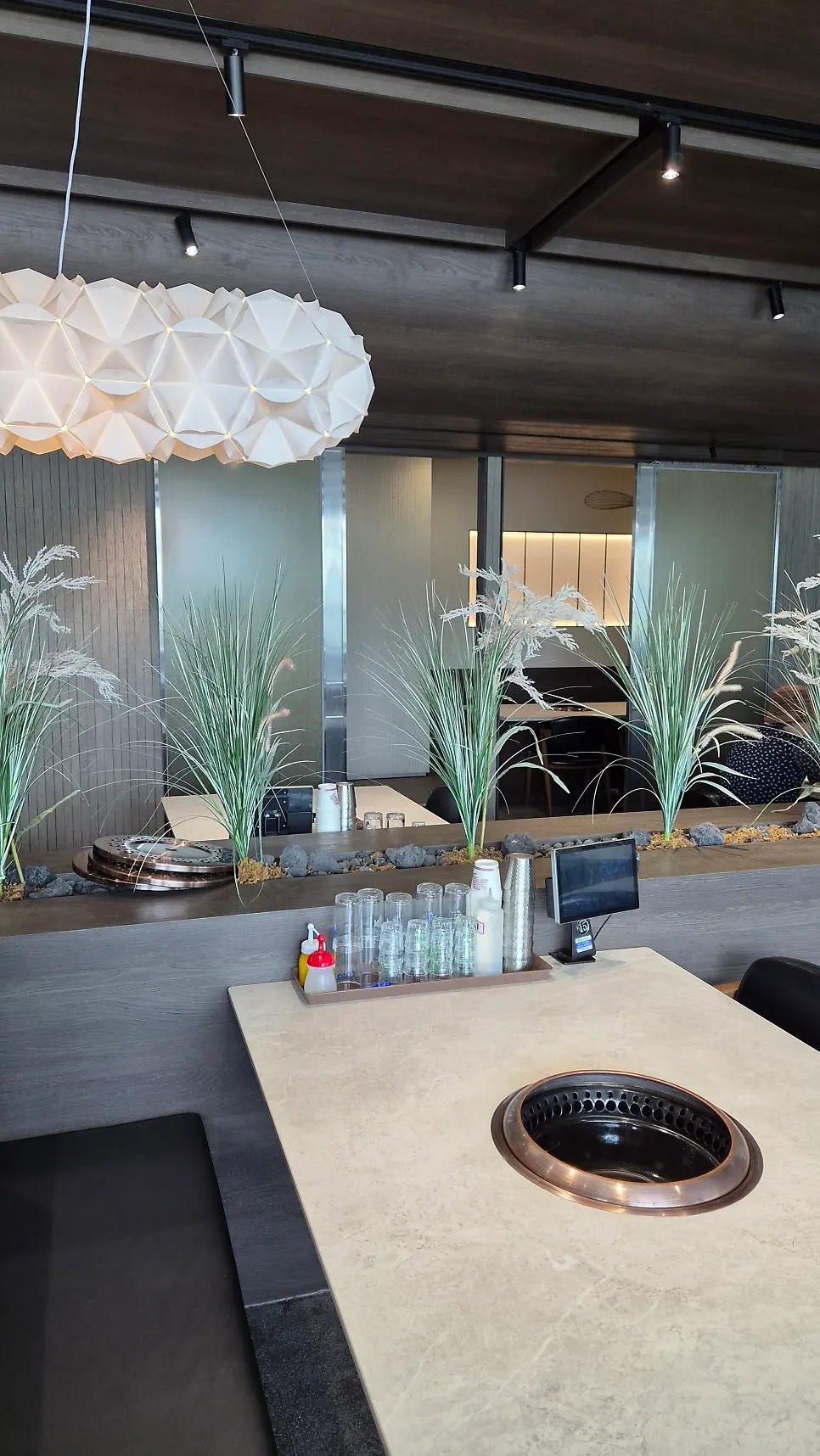 Interior with plant decor and generously spaced tables