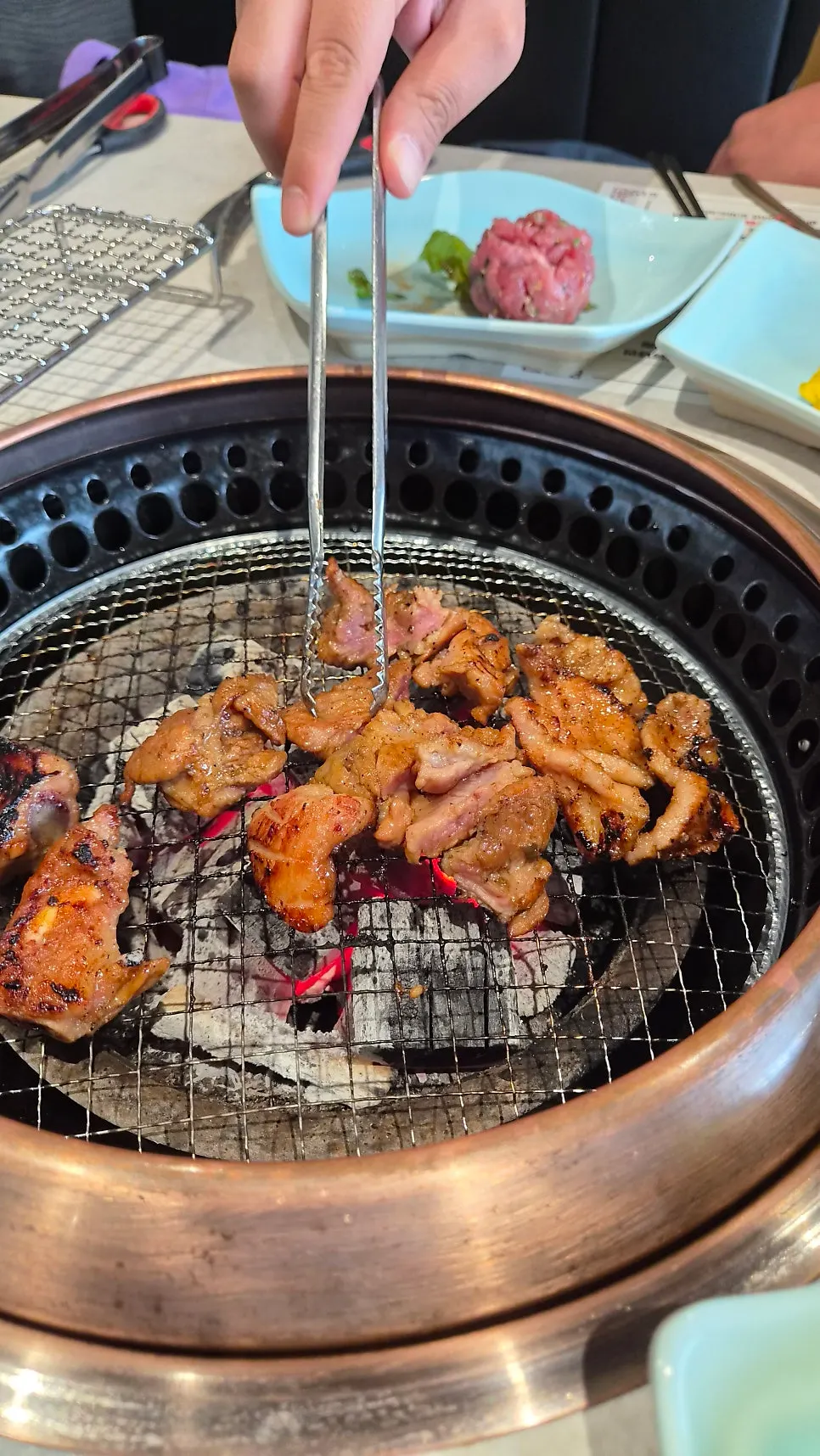 Seasoned handmade galbi placed on the charcoal grill grate