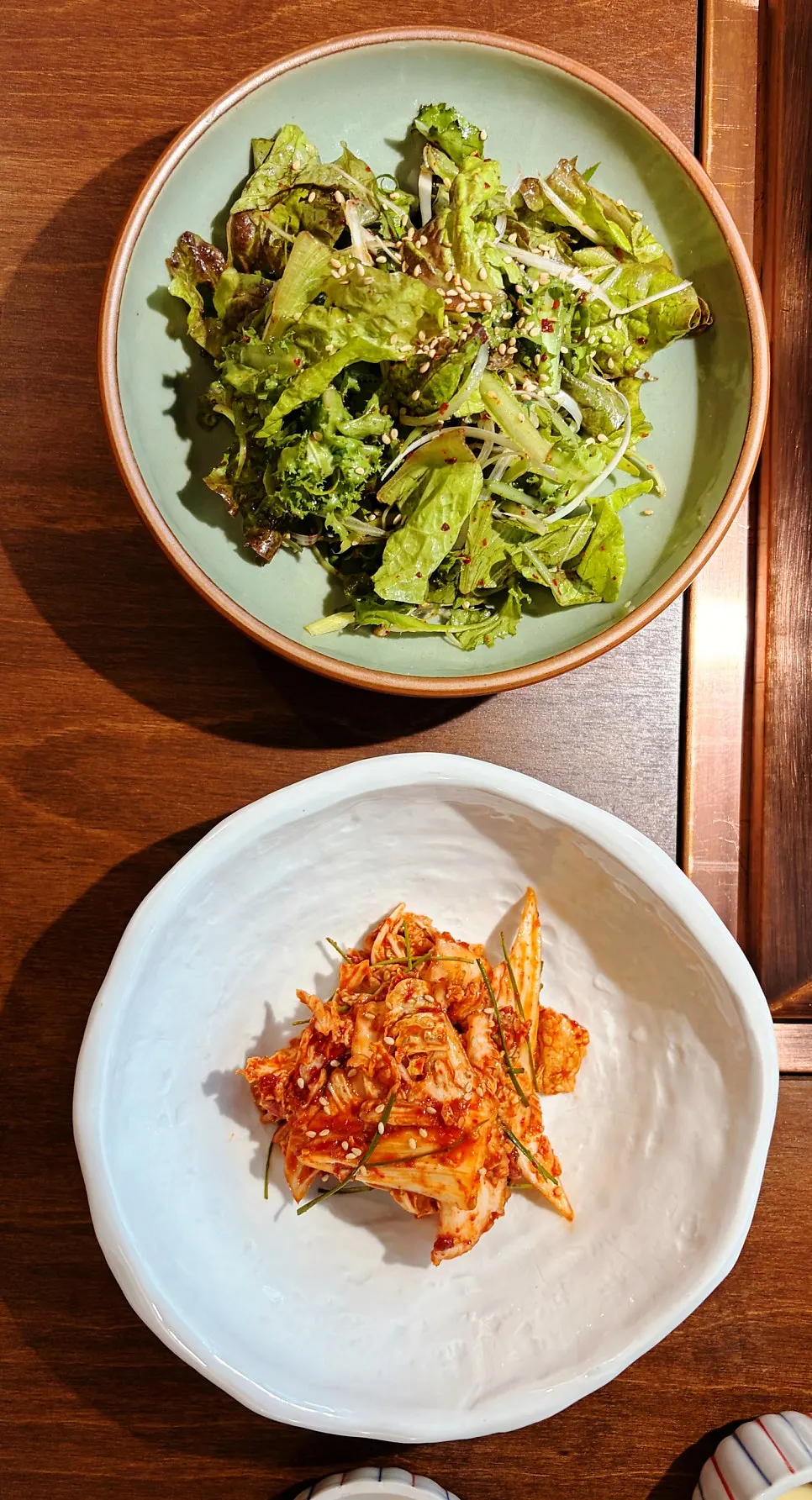 Plates of lettuce-scallion geotjeori and napa cabbage geotjeori