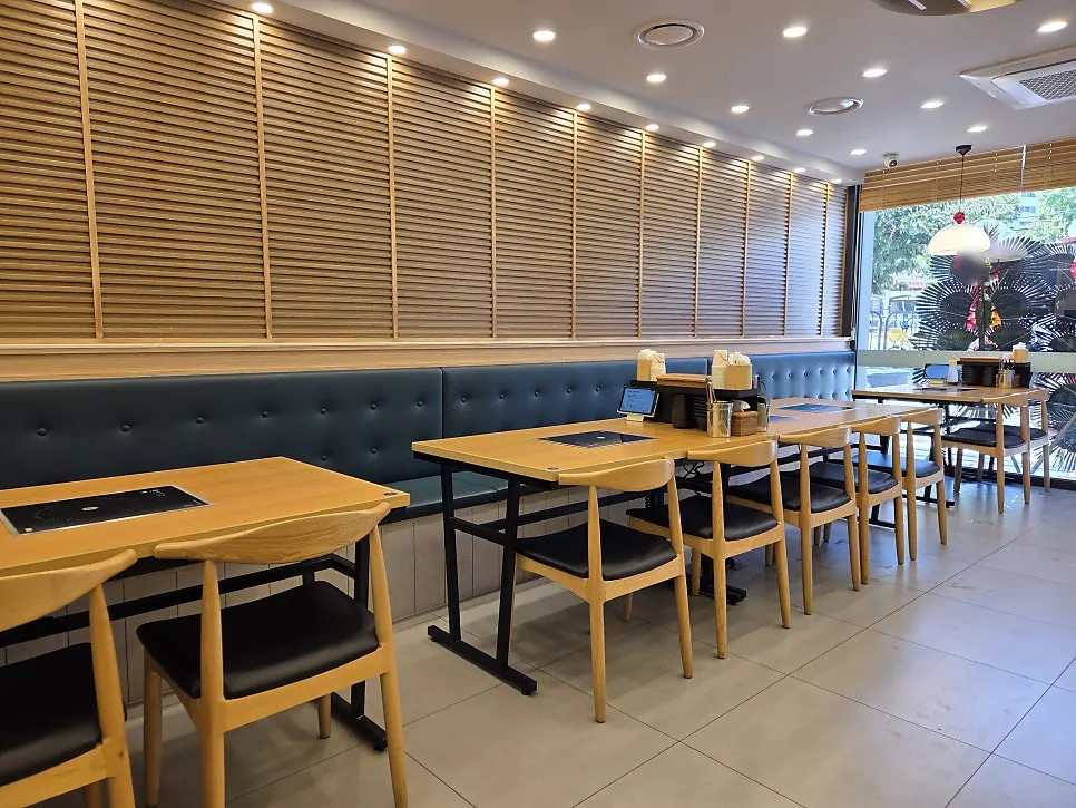 Interior of Mansu Shabu Kalguksu decorated in deep green and wood