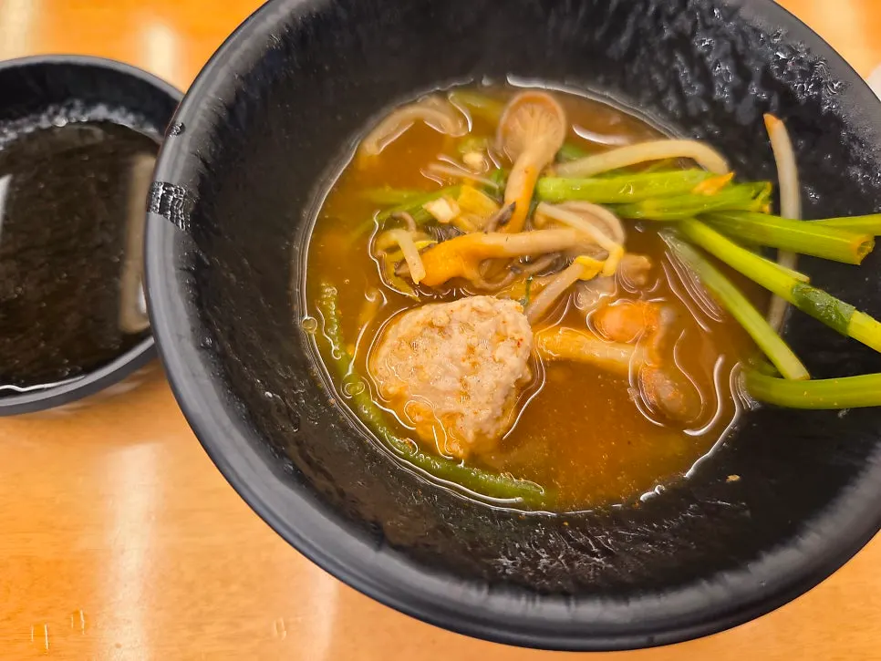 Meatballs added into the boiling spicy broth