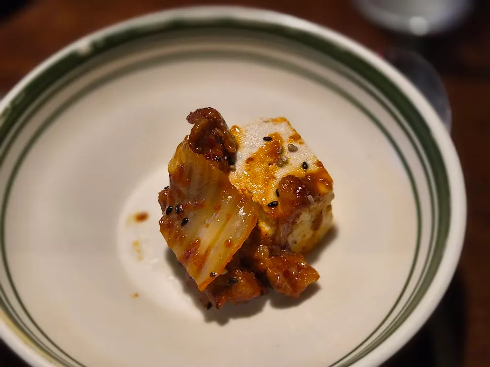Tofu split into pieces with chopsticks