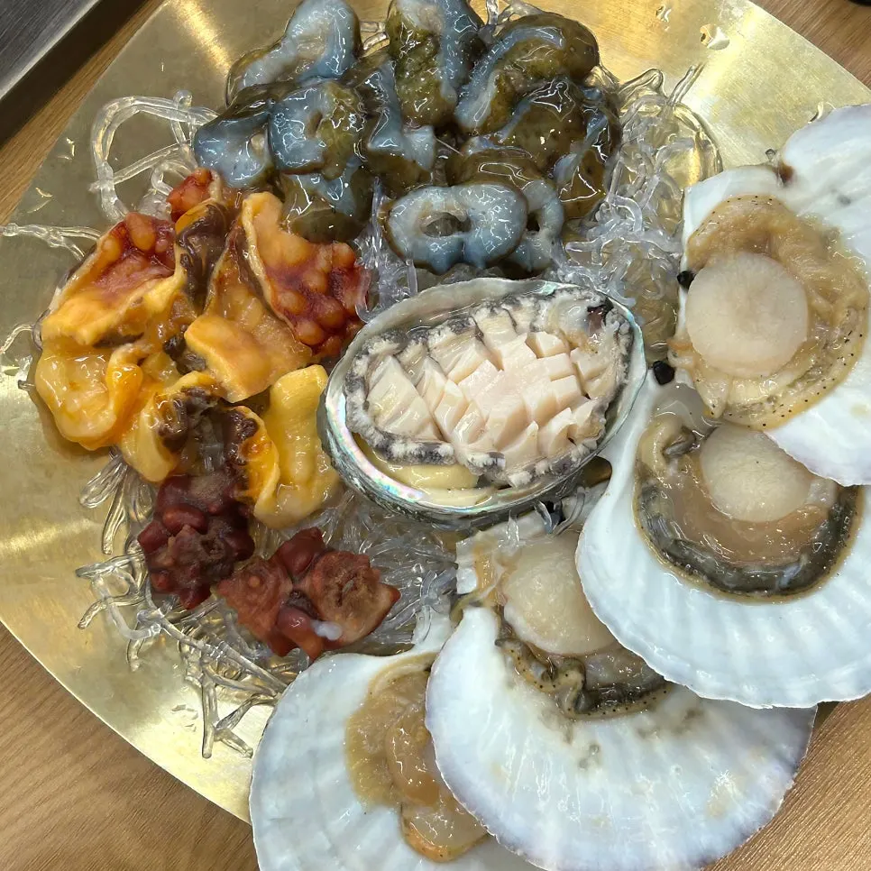 ホタテ刺身とアワビ刺身が盛られた海鮮盛り合わせ
