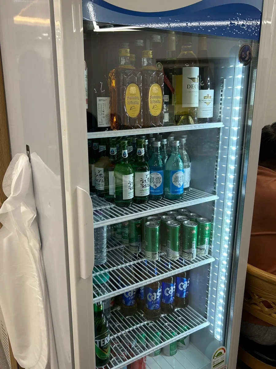 Drinks fridge stocked with a variety of alcohol
