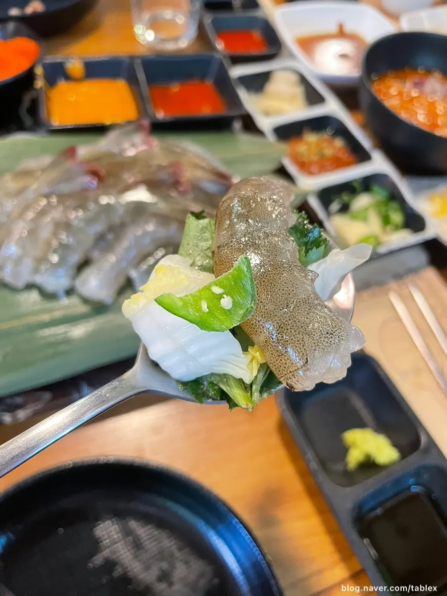 Raw shrimp sashimi topped with chipotle sauce and flying fish roe