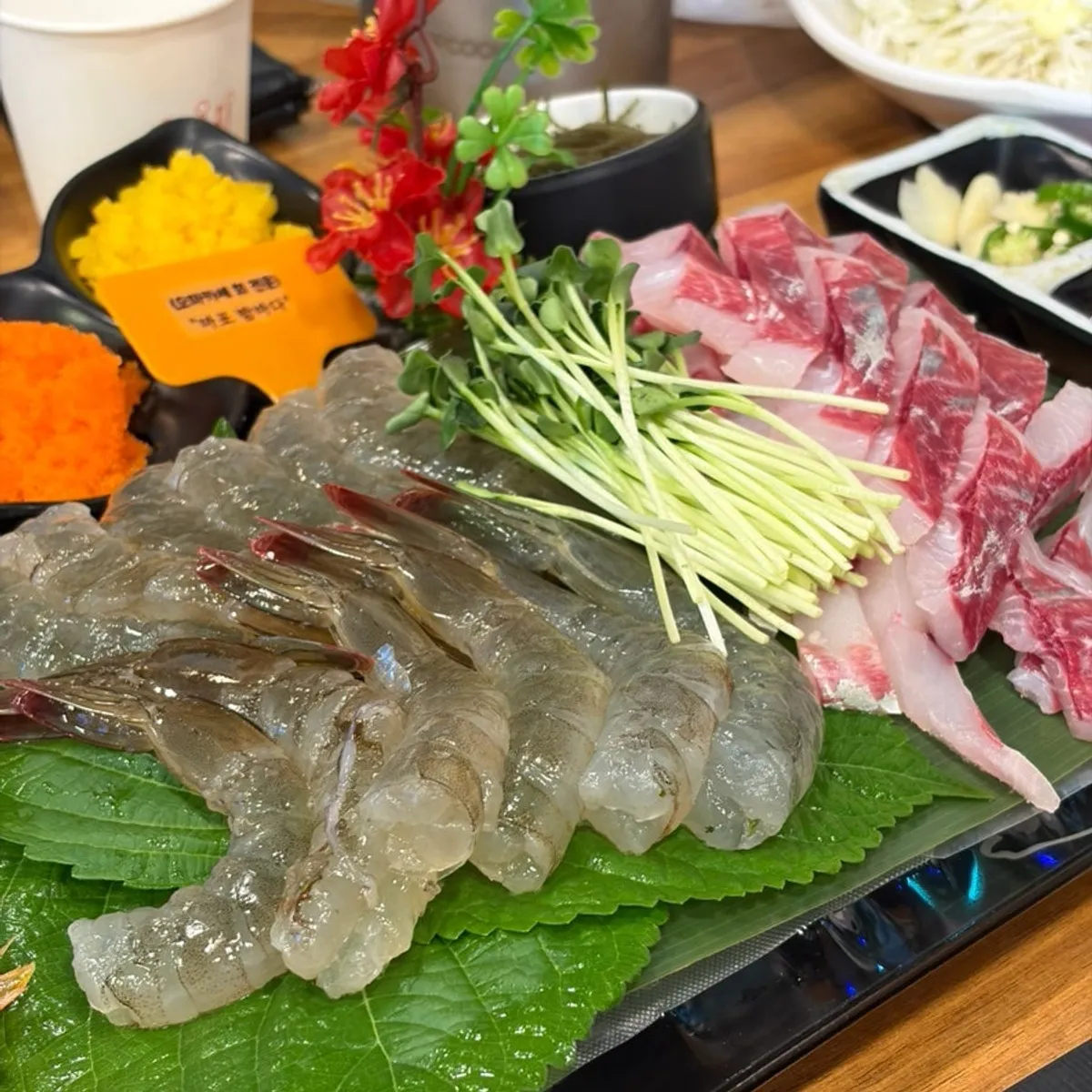 Full table spread of raw shrimp sashimi at Mapo Bamdada