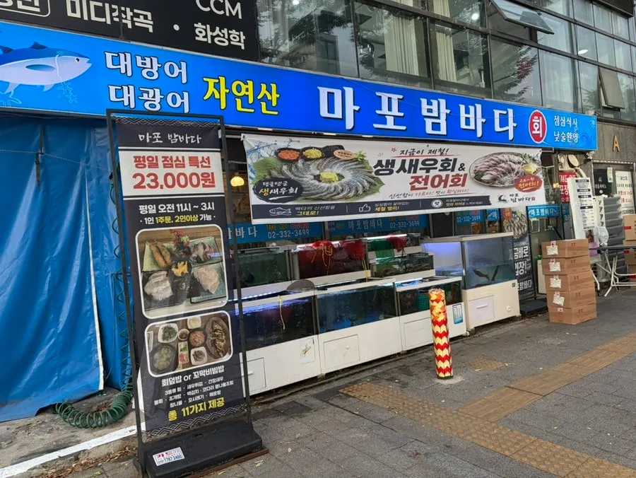 Exterior of Mapo Bamdada with signs for seasonal raw shrimp sashimi and gizzard shad sashimi