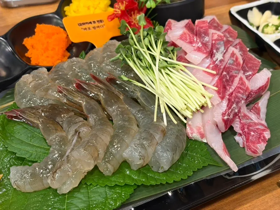 Plate of peeled raw shrimp sashimi and mullet sashimi