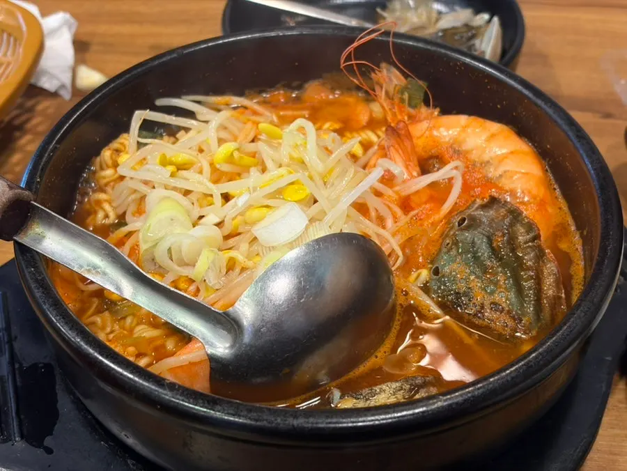 Complimentary grilled fish topped with bean sprouts and spicy sauce