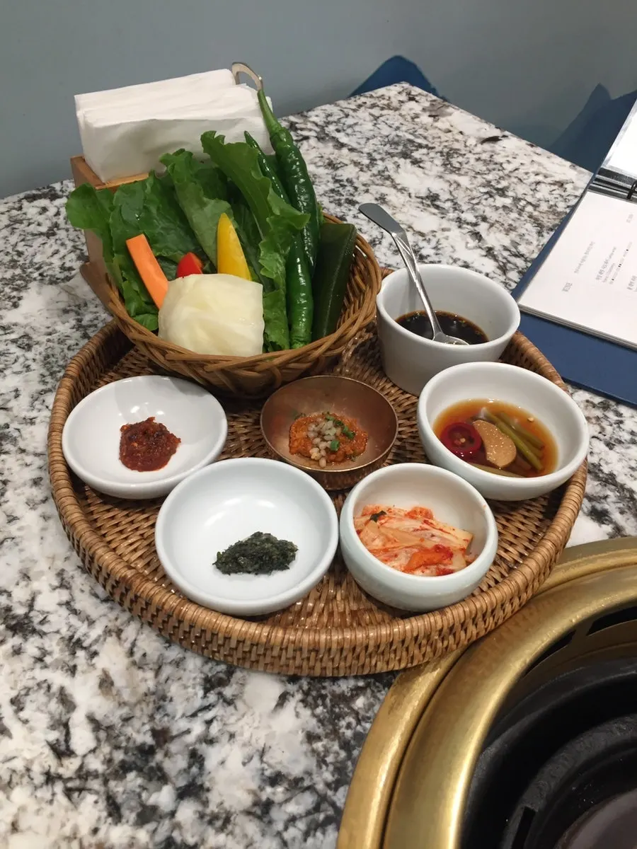 반찬과 쌈채소가 놓인 룸 테이블 상차림