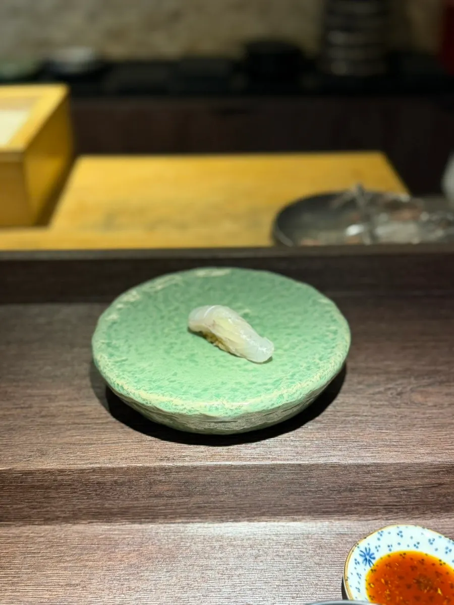The first piece served, flounder sushi