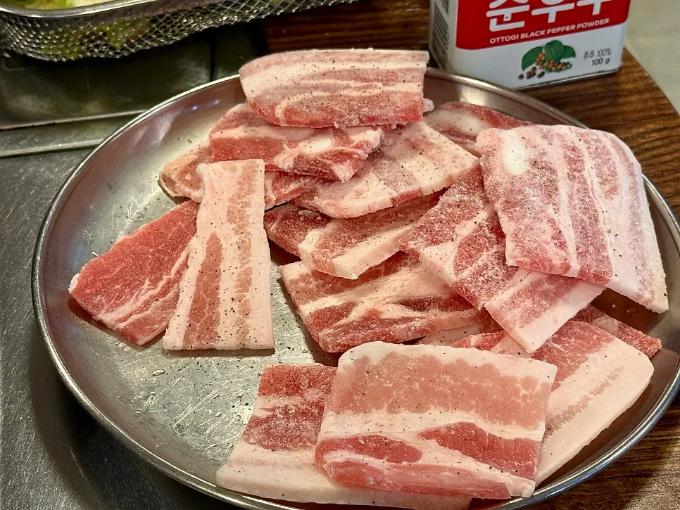 불판에서 구워지는 냉동삼겹살과 김치