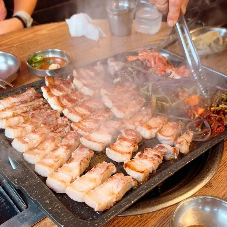 きつね色に焼けたサムギョプサルと一緒に焼くネギキムチ